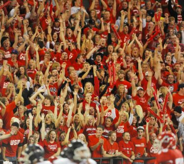Coyote students cheer in the stands at a football game.