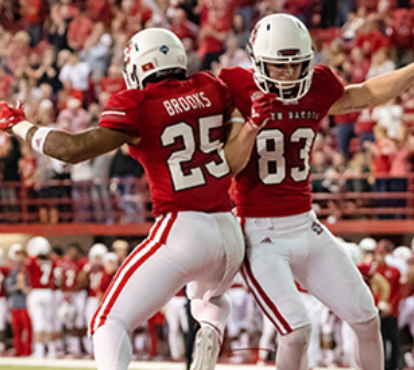 Two Coyote football players celebrate during a game at the DakotaDome.
